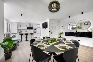 a dining room and kitchen with a table and chairs at Las Flores Luxury Apartment in Málaga