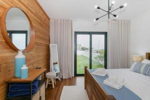1 dormitorio con espejo grande y cama en GuestReady - Good Vibes, en Ponta Delgada