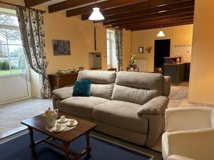a living room with a couch and a table at Les petites chaumes in Champagné-le-Sec