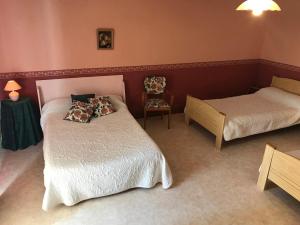 a bedroom with two beds and a table and a chair at Les petites chaumes in Champagné-le-Sec