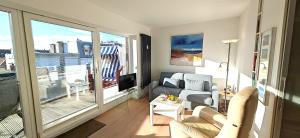 a living room with a couch and a balcony at Sommertraum im 3 Jahreszeiten in Norderney