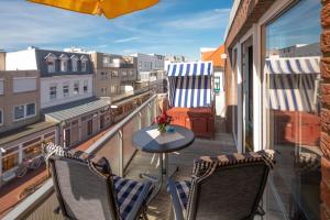 a balcony with two chairs and a table on a balcony at Sommertraum im 3 Jahreszeiten in Norderney