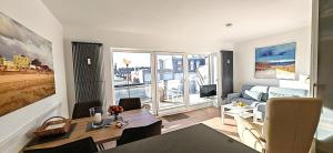 a living room with a couch and a table in a room at Sommertraum im 3 Jahreszeiten in Norderney