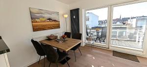 a dining room with a table and a large window at Sommertraum im 3 Jahreszeiten in Norderney +7 photos