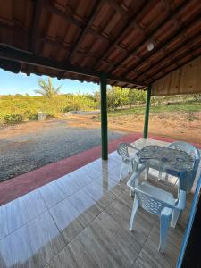 a patio with a table and chairs on a porch at Chalés Relíquias da Canastra I in São Roque de Minas