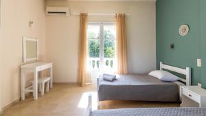 a bedroom with a bed and a window at Neos Alexandros by Go4sea in Kato Korakiana +14 photos