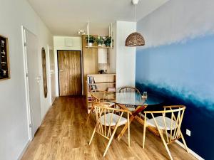a dining room with a glass table and chairs at Błękitna Keja - apartament z widokiem na jezioro - Zegrze in Zegrze