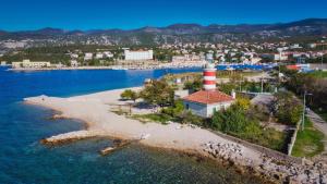 an island with a lighthouse in the middle of the water at Kvarner View Rooms in Kraljevica