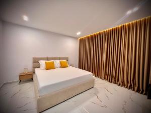 a bedroom with a bed with yellow pillows at Dine Hotel in Ksamil