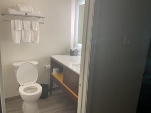a bathroom with a toilet and a sink with towels at Holiday Inn Houston Intercontinental Airport by IHG in Houston