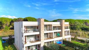 un immeuble d'appartements avec des arbres en arrière-plan dans l'établissement San Pietro Happy Stay 300, à Lalzit Bay