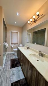 a bathroom with two sinks and a large mirror at Massive Luxury Retreat with Gym, Sauna, Games and More in Mississauga +42 photos