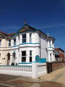 a white house with blue trim on a street at The Townhouse 101 in Sandown