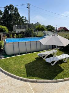a pair of chairs and an umbrella next to a swimming pool at Chalet Miracies in Hio