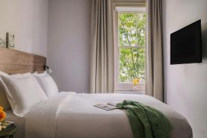 a bedroom with a white bed with a window at The Gilbert Hotel Kensington, Sonder Hotel by Marriott Bonvoy in London +38 photos