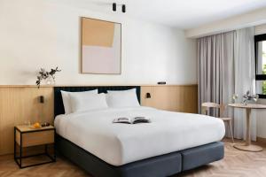 a bedroom with a large white bed and a table at Aspasios Sofia Atocha Aparthotel in Madrid