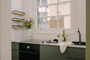 a kitchen with a counter with a window and a sink at Chelsea Green Hotel, Sonder by Marriott Bonvoy in London