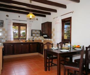 a kitchen with a table and a dining room at Finca La Crucita - Órzola in Haría