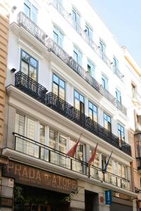 un edificio blanco con balcón y banderas. en Sonder by Marriott Bonvoy Santa Ana Apartments Las Letras, en Madrid
