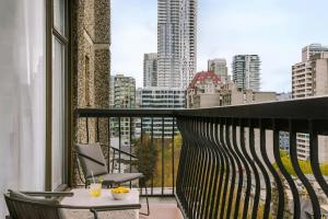 a balcony with a table and a view of a city at The Sunset Hotel West End in Vancouver