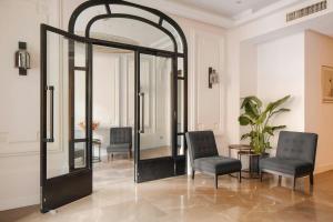 a room with two chairs and a mirror at L'Edmond Hotel Parc Monceau in Paris