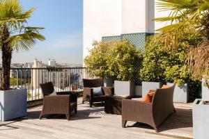a patio with chairs and tables on top of a building at L'Edmond Hotel Parc Monceau in Paris