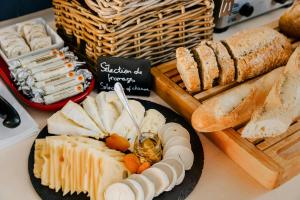 a table with cheese and bread and a plate of food at L'Edmond Hotel Parc Monceau in Paris +70 photos