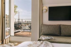 a bedroom with a couch and a view of a balcony at Atala Hotel Champs Elysées, Sonder by Marriott Bonvoy in Paris