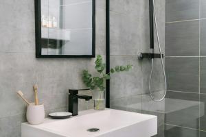 a bathroom with a white sink and a shower at Atala Hotel Champs Elysées, Sonder by Marriott Bonvoy in Paris