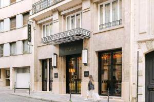 a woman walking in front of a building at Atala Hotel Champs Elysées, Sonder by Marriott Bonvoy in Paris