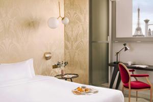 a hotel room with a bed and a red chair at Atala Hotel Champs Elysées, Sonder by Marriott Bonvoy in Paris