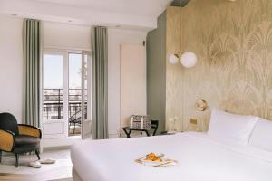 a bedroom with a white bed and a balcony at Atala Hotel Champs Elysées, Sonder by Marriott Bonvoy in Paris