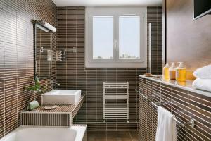 a bathroom with a sink and a bath tub at Atala Hotel Champs Elysées, Sonder by Marriott Bonvoy in Paris