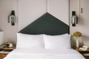 a bed with a black and white headboard and white pillows at Atala Hotel Champs Elysées, Sonder by Marriott Bonvoy in Paris