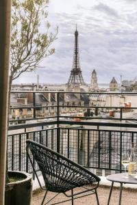 a chair on a balcony with a view of the eiffel tower at Atala Hotel Champs Elysées, Sonder by Marriott Bonvoy in Paris