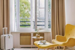 a living room with a yellow chair and a window at Atala Hotel Champs Elysées, Sonder by Marriott Bonvoy in Paris