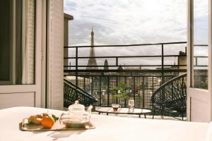 a table with a plate of fruit and a view of the eiffel tower at Atala Hotel Champs Elysées, Sonder by Marriott Bonvoy in Paris