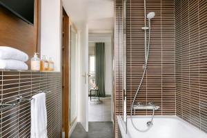a bathroom with a bath tub and a shower at Atala Hotel Champs Elysées, Sonder by Marriott Bonvoy in Paris
