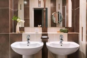 a bathroom with two sinks and a mirror at Atala Hotel Champs Elysées, Sonder by Marriott Bonvoy in Paris