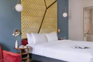 a bedroom with a white bed and a red chair at Atala Hotel Champs Elysées, Sonder by Marriott Bonvoy in Paris