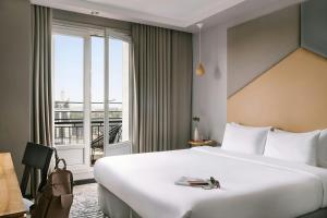 a hotel room with a large bed and a window at Atala Hotel Champs Elysées, Sonder by Marriott Bonvoy in Paris