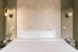 a bedroom with a large bed with white sheets at Atala Hotel Champs Elysées, Sonder by Marriott Bonvoy in Paris