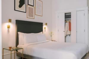 een slaapkamer met een groot wit bed en een kast bij Kensington Gardens Hotel, Sonder by Marriott Bonvoy in Londen
