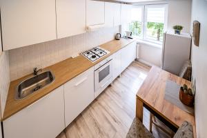 シャウレイにあるThibo Apartamentasの白いキャビネットとシンクのあるキッチン