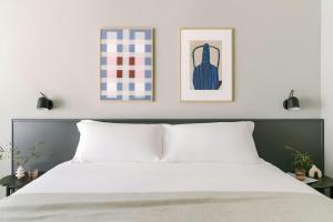 a bedroom with a bed with two pictures on the wall at Testaccio Hotel Monte dei Cocci, Sonder by Marriott Bonvoy in Rome