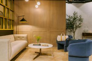 a living room with a couch and two chairs and a table at Nester Finn West Queen West in Toronto