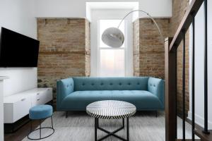 Una sala de estar con un sofá azul y un televisor. en Sonder by Marriott Bonvoy Gare Saint Denis Apartments Downtown, en Montreal 65 fotos más