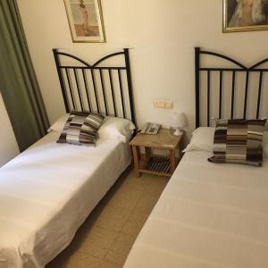 two beds sitting next to each other in a bedroom at Hostal Tres Cantos in Tres Cantos