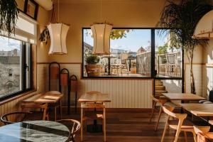 ein Restaurant mit Tischen, Stühlen und Fenstern in der Unterkunft Hotel Casa Luz in Barcelona