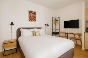 Un dormitorio con una cama blanca y un televisor. en Quintinie Hotel 15th Arrondissement, Sonder by Marriott Bonvoy, en París 33 fotos más